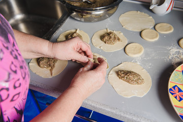 Senior woman prepares khinkali.