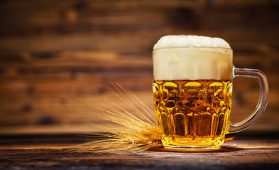 Glass of lager served on old wooden planks,