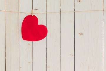 Blank red heart hanging on white wood with space for Valentine a