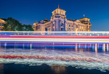 Berlin government district with Reichstag and light trails of a ship on Spree river in twilight, Berlin Mitte, Germany