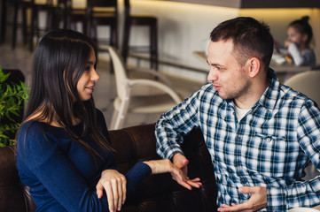 Happy couple talking at cafe, drinking tea