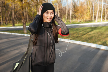 Young fitness woman in warm clothes and earphones