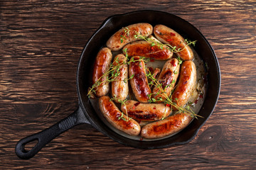 Home-made Pork Sausages in rustic pan with thyme