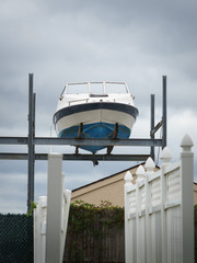White blue boat on land lifted up on metal construction - 130096094