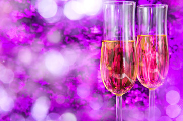 Two champagne glasses on the violet party background