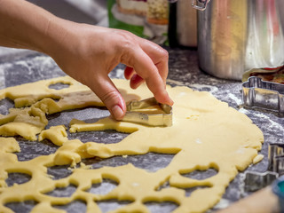 Baking cookies for Christmas. Young woman making shaped cookies.
