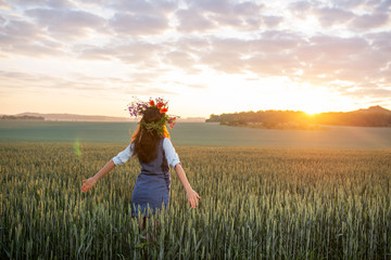 girl in a wreath greets the sunrise in the field