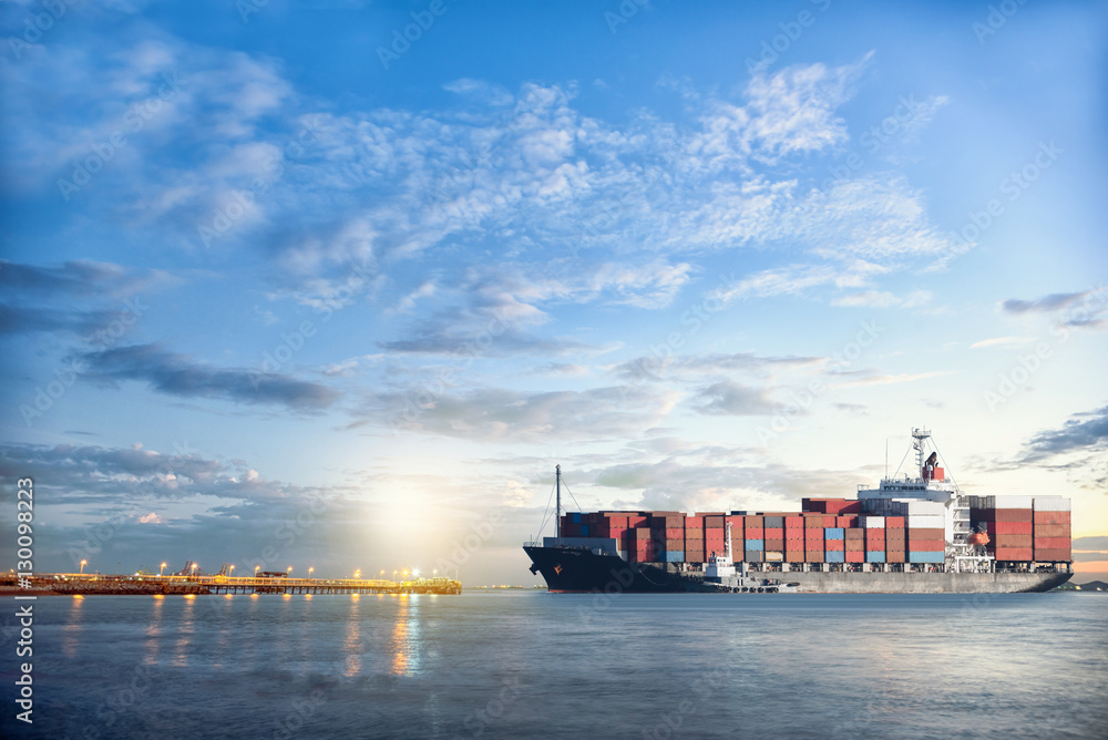 Wall mural logistics and transportation of international container cargo ship in the ocean at twilight sky, fre