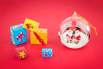 Transparent Christmas ball with Santas inside  and gift boxes