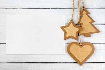 Blank greeting card and Christmas decorations on white wooden background