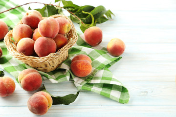 Sweet peach fruit in basket on white wooden table