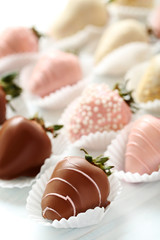 Strawberries covered in chocolate on a white wooden table