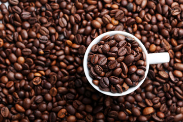 Brown roasted coffee beans in white cup
