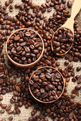 Brown roasted coffee beans in bowl on sackcloth