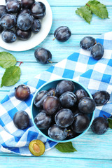 Tasty and ripe plums on blue wooden table