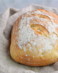 fresh baked homemade sourdough bread loaf wrapped in linen