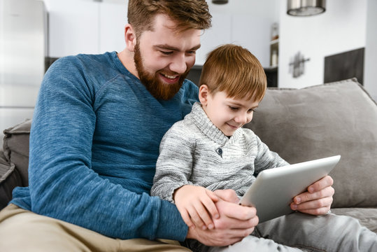 Cheerful family using tablet computer indoors