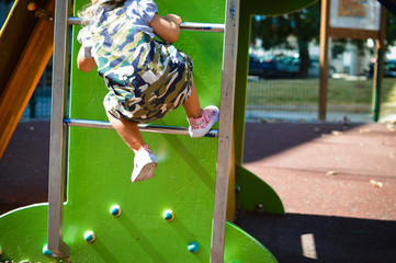 Closeup on child legs active in the playground on city park outdoors background