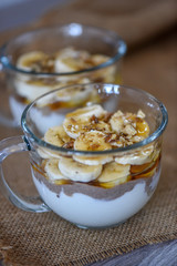 Granola with yogurt, bananas and whole walnuts, maple syrup clea