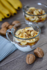 Granola with yogurt, bananas and whole walnuts, maple syrup clea