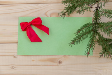 Копозиция с еловой веткой , поздравлением и подарком к Рождеству и Новому году на деревянном фоне. Концепция международные празднования.