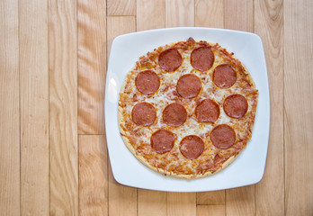 Pepperoni pizza on a wooden background