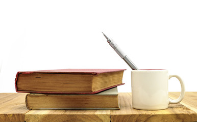 A Old books with coffee cup and a silver pencil on the wood table and white background