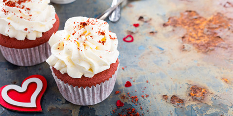Delicious red velvet cupcakes for Valentines Day on rusty old metal background. Holiday food concept. Copy space.