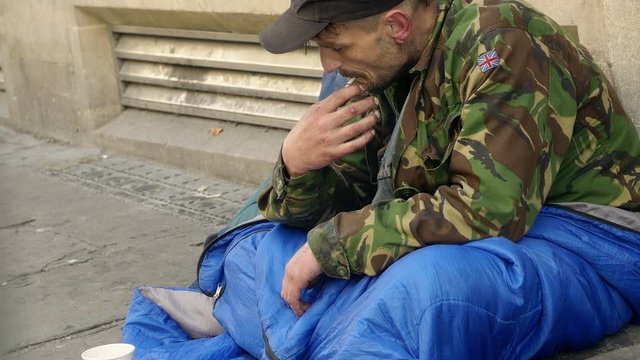 job loss, economic crisis: a young man living in the street begging 