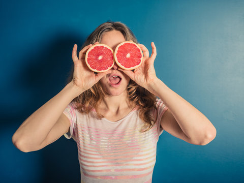 Young woman with grapefruit binoculars
