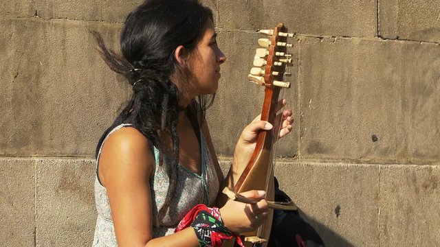 young woman playing old string instrument the gusle