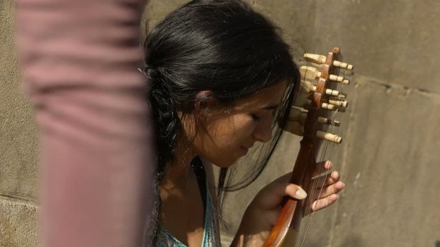 street artist, young woman playing on the sidewalk