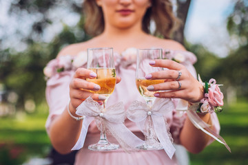 Delighted bridesmaid holding the glass of champagne outdoor