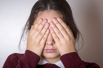 Chica joven con las manos tapando sus ojos