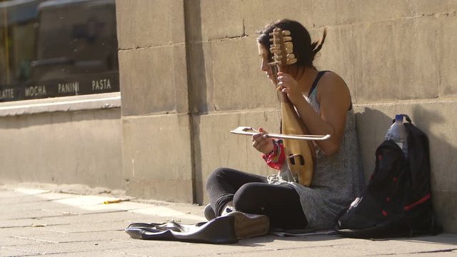begging street artist sitting on the sidewalk