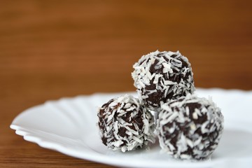 Christmas sweets on a plate - Rum balls in coconut. Traditional homemade handmade Czech sweets.