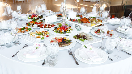 decorated table with meal and tableware at wedding reception