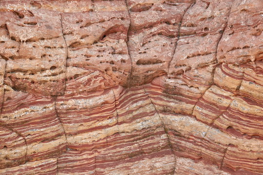 Sandstone wall with red and salmon layers and cracks, Vermillion Cliffs National Monument, Arizona 