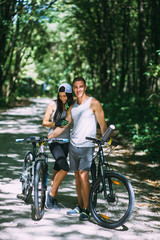 Obraz premium Young Couple Riding Bike In Park