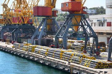 Fototapeta na wymiar new pipes in the industrial port, cargo cranes and infrastructure