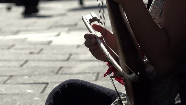 playing a string instrument: bow, melody, street music, street artist