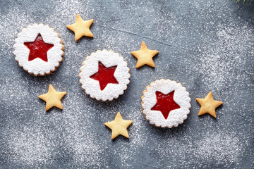 Linzer star cookies with berry jam filling traditional Christmas Austrian sweet dessert food Xmas celebration pastry powdered holiday snack on vintage table background. Flat lay