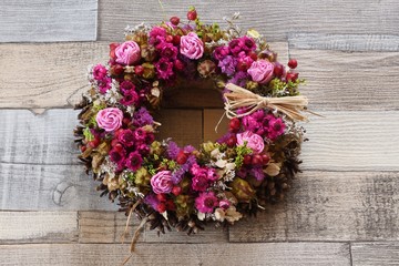 Fototapeta na wymiar Wreath of dried flowers on wooden background
