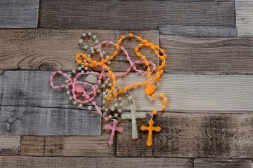 Color rosary beads on wooden background