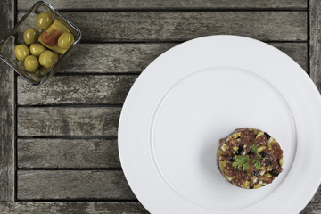 Steak tartar sobre mesa de madera.