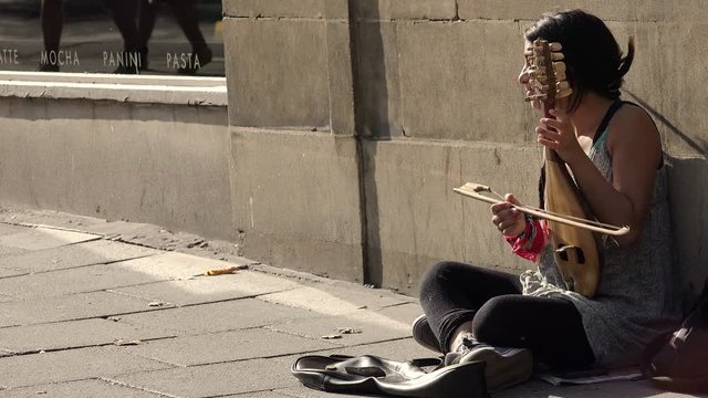 beggar woman playing music and asking charity