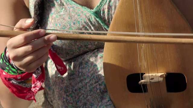 old european string instrument: young street artist woman playing a old string 
