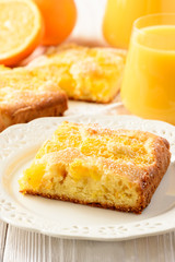 Orange cake and orange juice on white wooden background.