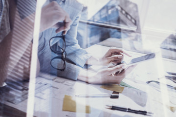 Closeup view of female hands touching screen modern smartphone.Concept business people using mobile gadgets.Double exposure,skyscraper office building blurred background.Horizontal, film effect.