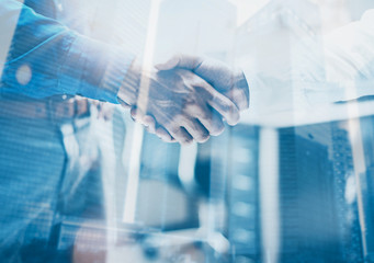 Double exposure concept.Close up view of business partnership handshake .Photo two businessman...